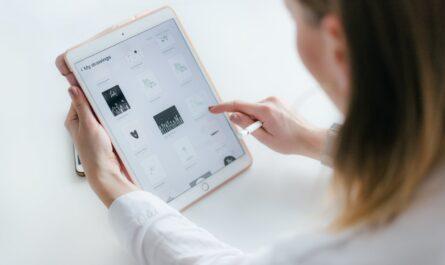 woman sitting beside table while using ipad